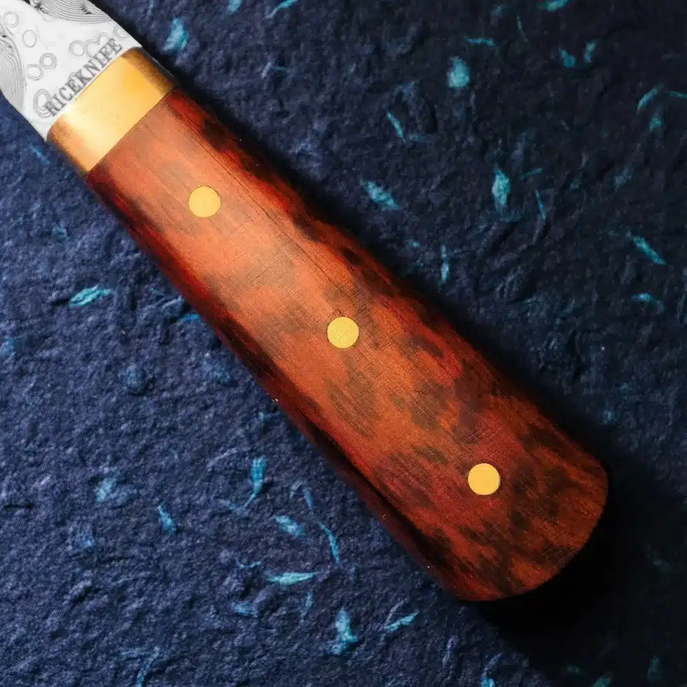 Nærbillede af snakewoodskaftet med mørkere pletter og tre stifter